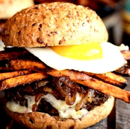 Quinoa burgers with sweet potato fries and caramelized onions and a fried egg